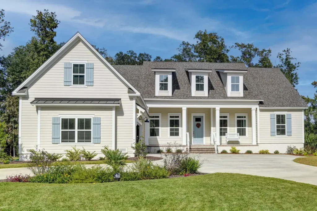 Home exterior with light siding, blue-gray shutters and a covered front porch