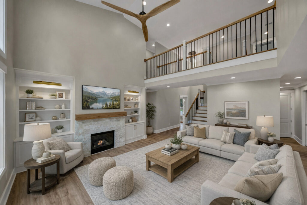 Two-story living room with a stone fireplace, built-in shelves and an upper landing