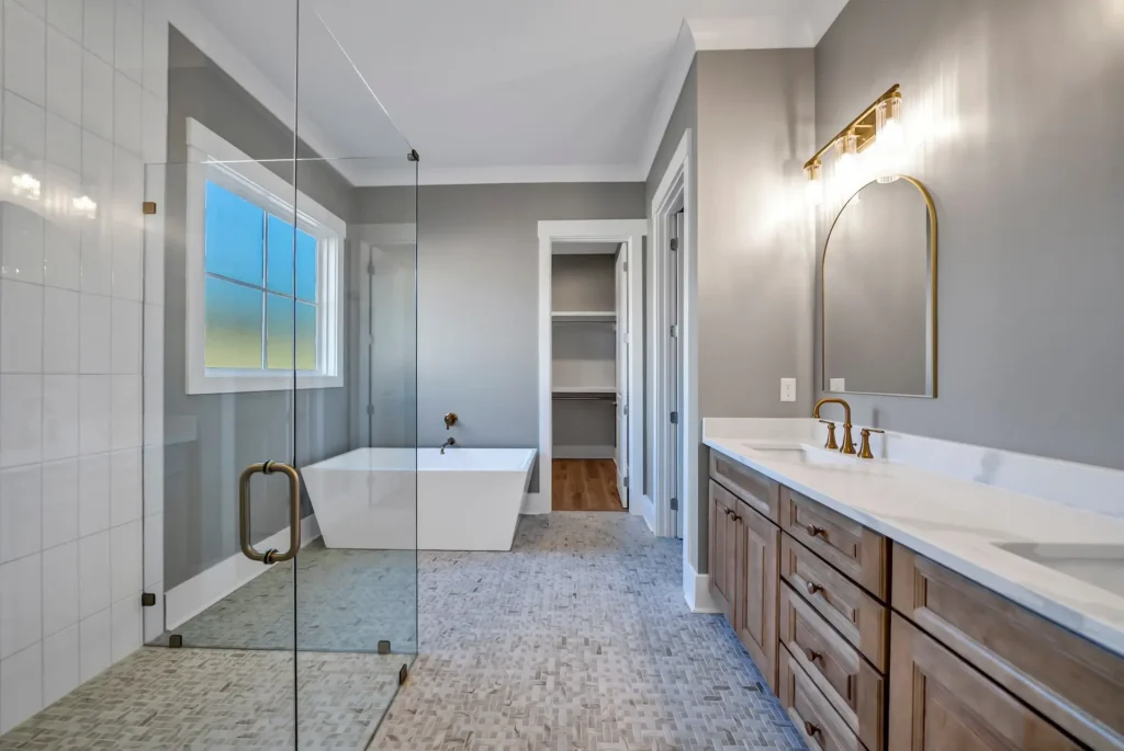 Bathroom with a glass shower, freestanding tub, wood vanity and patterned floor tile